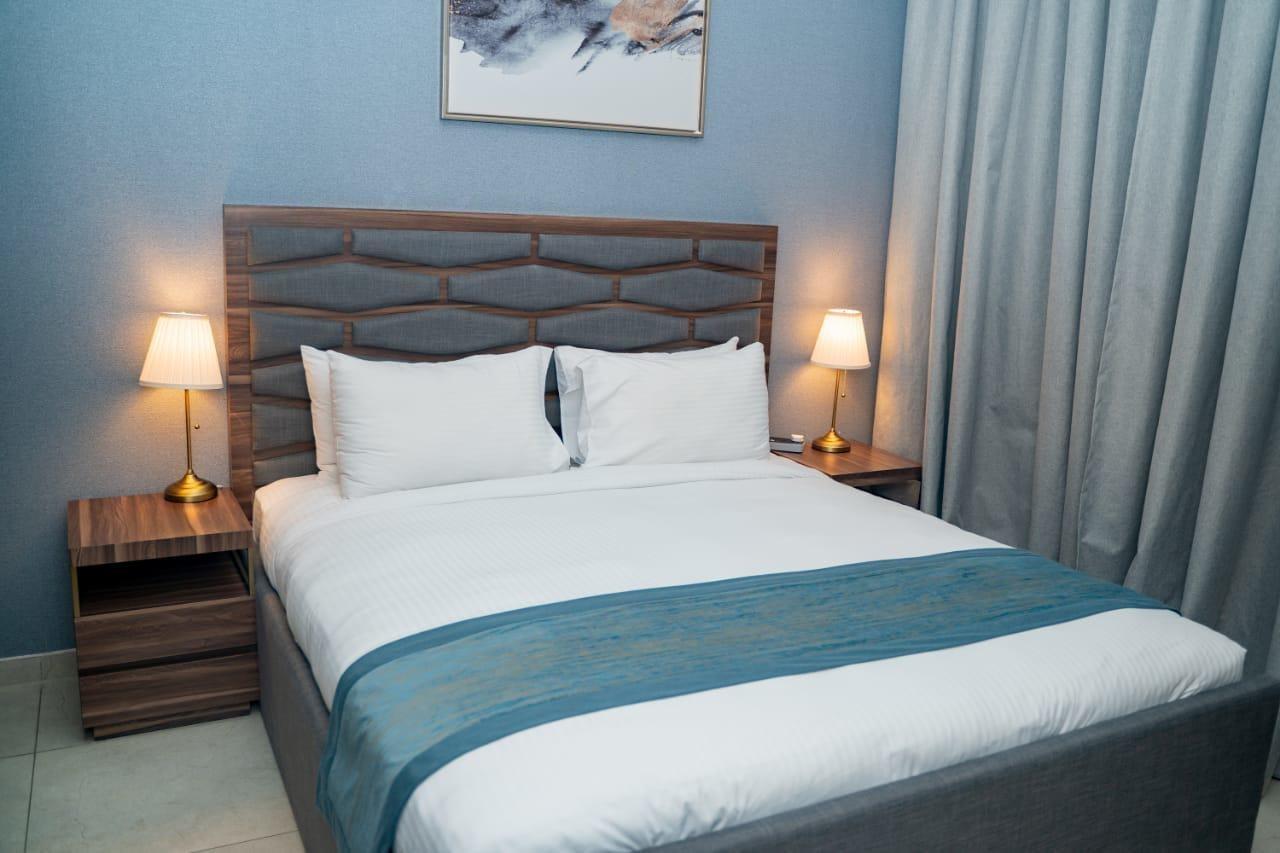 Luxe Grand Hotel Apartments Sharjah Exteriör bild A bed with a bed runner